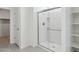 Bright bathroom showcasing glass-enclosed shower and shelving unit at 17744 W Hatcher Rd, Waddell, AZ 85355