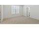 Bedroom featuring neutral carpet, a window, and a door to the bathroom at 17744 W Hatcher Rd, Waddell, AZ 85355