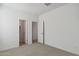 A clean bedroom features neutral carpet, fresh paint, and two access doors at 17744 W Hatcher Rd, Waddell, AZ 85355