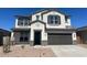 Charming two-story home boasts a neutral color scheme, a two-car garage, and a well-maintained front yard at 17744 W Hatcher Rd, Waddell, AZ 85355