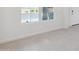 Cozy living space showcasing neutral tile flooring, and white walls, bathed in natural light from a nearby window at 17744 W Hatcher Rd, Waddell, AZ 85355