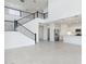 Open floor plan with staircase adjacent to kitchen which features stainless steel appliances and white cabinetry at 17744 W Hatcher Rd, Waddell, AZ 85355