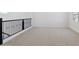 Carpeted loft space with black railing and ample natural light at 17744 W Hatcher Rd, Waddell, AZ 85355