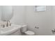 Stylish powder room features a pedestal sink, round mirror, and modern fixtures at 17744 W Hatcher Rd, Waddell, AZ 85355