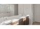 Bathroom featuring double sink vanity with white countertops, framed mirror, and a tiled shower at 17788 W Getty Dr, Goodyear, AZ 85338