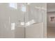 Bright bathroom features a glass shower with white tile and fixtures at 17788 W Getty Dr, Goodyear, AZ 85338