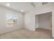 Bright bedroom with carpet flooring, a large window, and an adjoining bathroom at 17788 W Getty Dr, Goodyear, AZ 85338