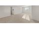 Large, bright bedroom with a neutral carpet, a large window, and white walls at 17788 W Getty Dr, Goodyear, AZ 85338