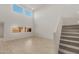 Bright living room with tile flooring, recessed lights, and an adjacent staircase at 17788 W Getty Dr, Goodyear, AZ 85338