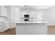 Modern kitchen island with stainless steel sink, white cabinets and stone countertops at 18377 W Gray Fox Trl, Wittmann, AZ 85361
