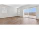 Bright living room with wood-look tile flooring and large sliding glass doors at 18377 W Gray Fox Trl, Wittmann, AZ 85361