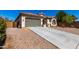 Charming single-story home with a gray two-car garage, concrete driveway, and desert landscaping under a blue sky at 1980 E Horseshoe Dr, Chandler, AZ 85249