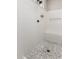 Modern tiled shower with pebble floor, bench, and built-in soap dispenser in neutral tones at 1980 E Horseshoe Dr, Chandler, AZ 85249