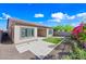 Expansive backyard shows synthetic grass, a covered patio, travertine, and vibrant flowering bushes at 2040 N Dome Rock --, Mesa, AZ 85207