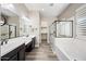 Bathroom with dual sinks, soaking tub, glass enclosed shower, and decorative lighting at 2040 N Dome Rock --, Mesa, AZ 85207