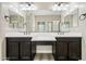 Bathroom featuring dual sinks, dark wood cabinetry, and decorative mirrors and lighting at 2040 N Dome Rock --, Mesa, AZ 85207