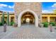 Clubhouse entrance featuring stone architecture, arched entryway, tiled pathway, and desert landscaping at 2040 N Dome Rock --, Mesa, AZ 85207