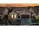 Charming single-story home boasts a tile roof, two-car garage, and beautifully landscaped front yard at sunset at 2040 N Dome Rock --, Mesa, AZ 85207