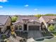 Charming single-story home boasts a tile roof, two-car garage, and beautifully landscaped front yard under a clear sky at 2040 N Dome Rock --, Mesa, AZ 85207