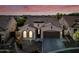 Charming single-story home boasts a tile roof, two-car garage, and beautifully landscaped front yard at sunset at 2040 N Dome Rock --, Mesa, AZ 85207