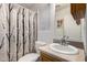 Cozy bathroom featuring a vanity with a sink, toilet, and a shower with patterned curtain at 2145 N Silverton St, Mesa, AZ 85203