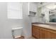 Bright bathroom with neutral countertops, white cabinets and toilet with wooden seat at 2145 N Silverton St, Mesa, AZ 85203