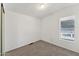 A minimalist bedroom featuring neutral carpeting, a window, and ample natural light at 2145 N Silverton St, Mesa, AZ 85203