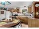 Cozy eat-in kitchen featuring oak cabinets, modern appliances, tile flooring, and ample natural light at 2145 N Silverton St, Mesa, AZ 85203