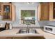 Well-lit kitchen featuring a stainless steel sink, bright countertops and oak cabinets at 2145 N Silverton St, Mesa, AZ 85203