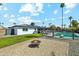 Backyard with pool, patio furniture, fire pit, green grass and palm trees under blue skies at 2405 E Balboa Dr, Tempe, AZ 85282
