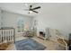 Bedroom featuring a crib, glider, side table with lamp, changing table, and neutral colors at 2405 E Balboa Dr, Tempe, AZ 85282
