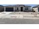 Charming single-story home featuring a gray garage door, stone accents, and a well-manicured gravel front yard at 25180 N 159Th Dr, Surprise, AZ 85387