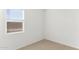 A bright, carpeted bedroom with neutral walls, large window, and electrical outlets at 25356 W Sunland Ave, Buckeye, AZ 85326