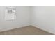 Neutral bedroom with carpet floors, window, and electrical outlets on a white wall at 25356 W Sunland Ave, Buckeye, AZ 85326