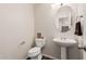 Stylish powder room with a pedestal sink, a decorative mirror, and modern fixtures at 3239 E San Manuel Rd, San Tan Valley, AZ 85143