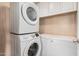 Bright laundry room features a stacked washer and dryer with storage cabinets and a chest freezer at 3239 E San Manuel Rd, San Tan Valley, AZ 85143