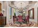 Elegant dining room with chandelier, custom rug, and large windows overlooking the landscape at 40635 N 109Th Pl, Scottsdale, AZ 85262
