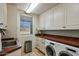 Laundry room with modern washer and dryer, neutral cabinets, and counter space at 40635 N 109Th Pl, Scottsdale, AZ 85262