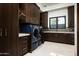 Well-appointed laundry room with ample storage, modern washer and dryer, and stylish countertops at 41248 N 96Th St, Scottsdale, AZ 85262