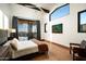 Bright main bedroom with a desert view, modern ceiling fan, and sleek floor to ceiling glass sliding doors at 41248 N 96Th St, Scottsdale, AZ 85262