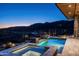 Inviting pool and spa glowing at twilight, set against a backdrop of desert landscape and distant lights at 41248 N 96Th St, Scottsdale, AZ 85262