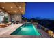 Inviting backyard pool with well-designed patio, stone accents, and ambient lighting for evening enjoyment at 41248 N 96Th St, Scottsdale, AZ 85262
