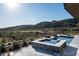 Luxury pool and spa with a waterfall feature, overlooking a lush desert landscape and mountain views at 41248 N 96Th St, Scottsdale, AZ 85262