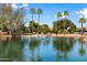 Beautiful pond view with a fountain, mature trees and blue sky at 672 Leisure World --, Mesa, AZ 85206