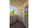 This balcony features stucco walls with an exterior light and a sliding glass door at 7494 E Earll Dr # 308, Scottsdale, AZ 85251