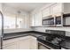 Well-lit kitchen featuring stainless steel microwave, black countertops, and ample cabinet space at 7494 E Earll Dr # 308, Scottsdale, AZ 85251