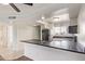 Condo kitchen boasts white cabinetry, black countertops, and stainless appliances at 7494 E Earll Dr # 308, Scottsdale, AZ 85251