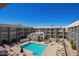 This pool has lounge chairs and tables with umbrellas in a community space at 7494 E Earll Dr # 308, Scottsdale, AZ 85251