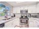 Well-lit kitchen with white cabinetry, stainless steel appliances, and granite countertops at 9451 E Becker Ln # 2013, Scottsdale, AZ 85260