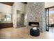 Modern bathroom featuring a stone fireplace, glass shower, double vanity and neutral tones at 9643 E Cintarosa Pass, Scottsdale, AZ 85262